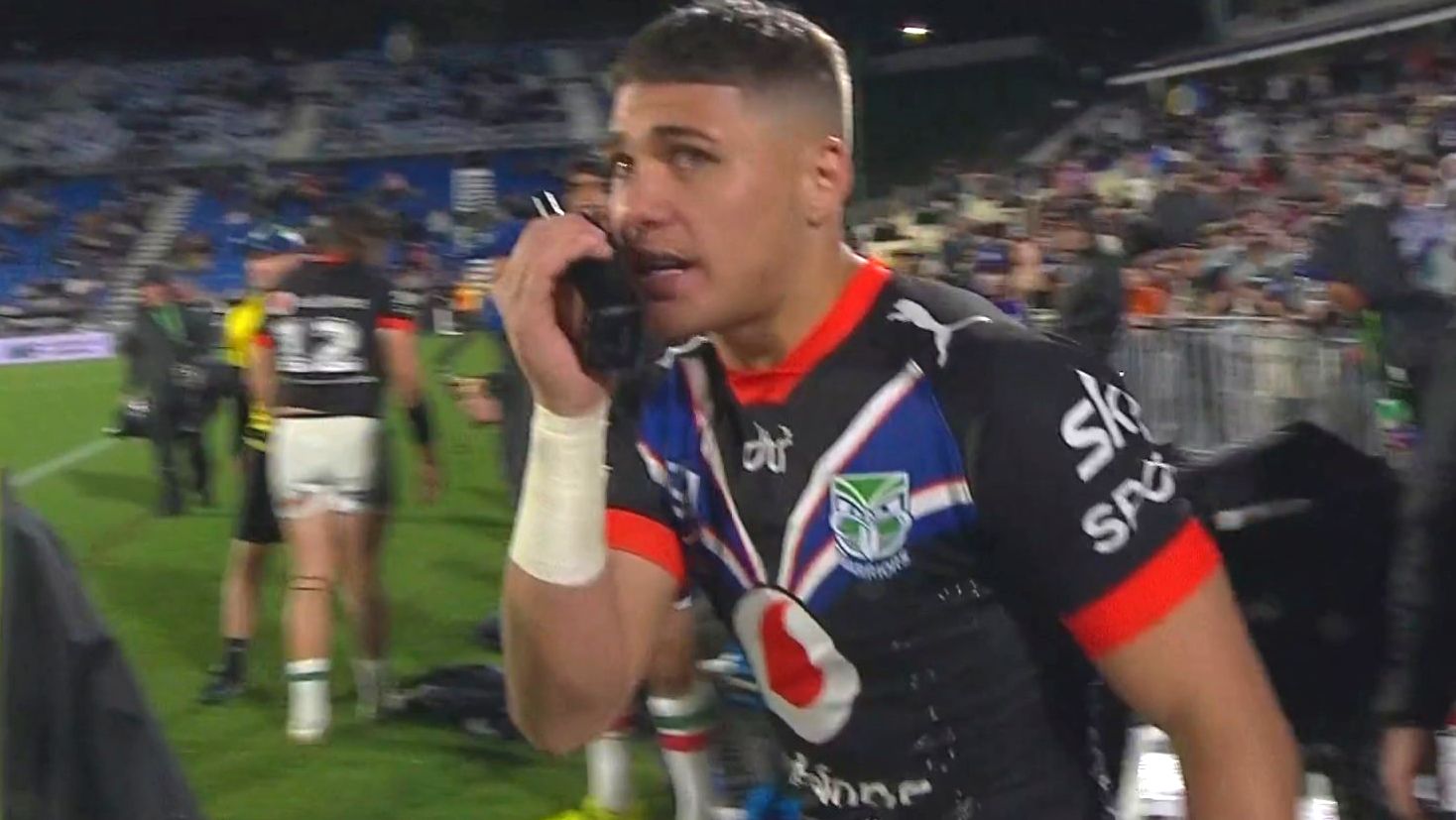 Warriors young gun Reece Walsh speaks to his coach over a walkie talkie.