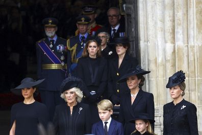 Camilla, the Queen Consort, Prince George, Princess Charlotte, Kate, Princess of Wales, Meghan, Duchess of Sussex, Sophie, Countess of Wessex, Princess Beatrice, Princess Eugenie, Prince Michael and Prince Edward stand after a service at Westminster Abbey