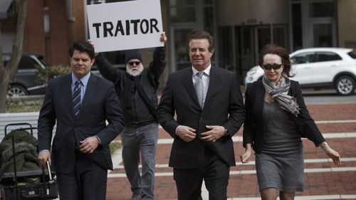 Paul Manafort (centre) is heckled as he walks into court.