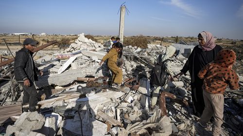 Members of the Abu Sheiban family salvage what they can of their belongings from under rubble of their destroyed home, days after the ceasefire deal between Israel and Hamas, in Rafah, southern Gaza Strip, Tuesday, Jan. 21, 2025. (AP Photo/Abdel Kareem Hana)