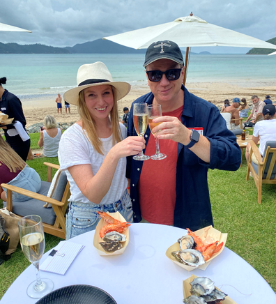 Guests of Qantas' Hamilton Island Mystery Flight relax with Champagne on the beach-facing lawn.