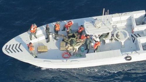 This image released by the US Department of Defence, taken from a US Navy helicopter, shows what the Navy says is the Islamic Revolutionary Guard Corps Navy after removing an unexploded limpet mine from the M/T Kokuka Courageous.