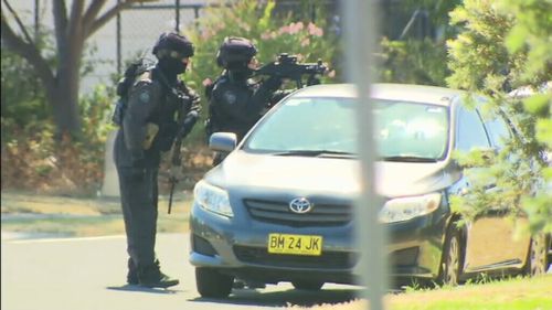 Police surrounding the sign factory. (9News)