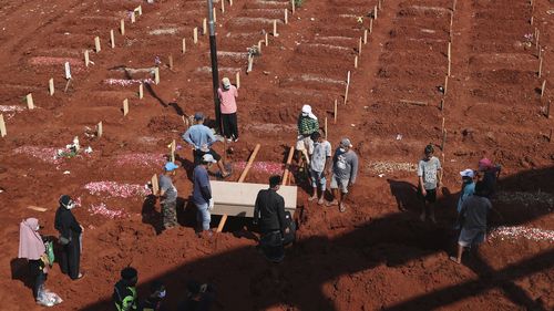 Workers prepare a coffin for burial at the special section of Jombang Public Cemetery reserved for those who died of COVID-19, in Tangerang, on the outskirts of Jakarta, Indonesia.