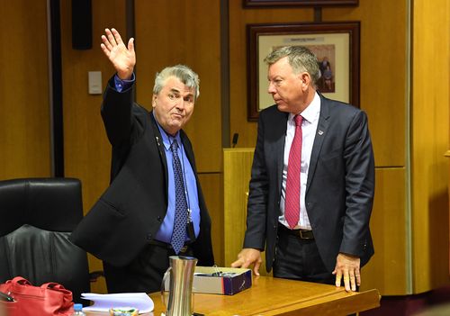 Cr David Pahlke waves goodbye as acting Mayor Wayne Wendt (right) looks on following the Ipswich City Council's final meeting at the Ipswich City Council Chambers