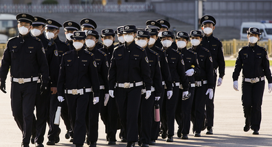 Chinese security personnel wearing protective masks march through Tiananmen Square during a national mourning to victims of COVID-19 on April 04, 2020 in Beijing, China.