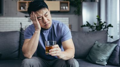 Man drinking scotch whisky hangover drinking scotch on couch