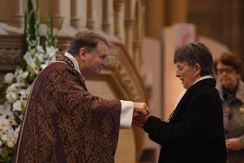 Catholic Archbishop of Sydney Anthony Fisher delivers communion to Pauline Johnson, the wife of John Richard Johnson. (AAP)