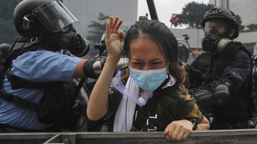 A protester is confronted by riot police during a massive demonstration outside the Legislative Council in Hong Kong. 