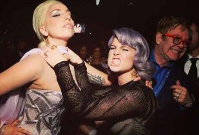 Eeek! Besties Lady Gaga and Kelly Osbourne play-fight (we hope) at Elton John's Oscars party... bonus points for Elton's impromptu photobomb!
