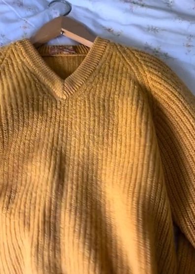 Yellow woollen jumper on clothes hanger