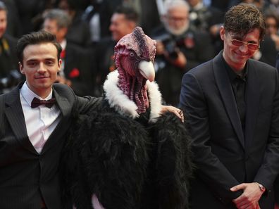 Raphael Quenard and Hugo David pose with a person dressed in bird costume at the premiere of the film Die, My Love at the 78th international film festival, Cannes, May 17, 2025.