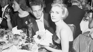 Joanne Woodward, named best actress for her role in The Three Faces of Eve, at a dinner table with her husband, Paul Newman.