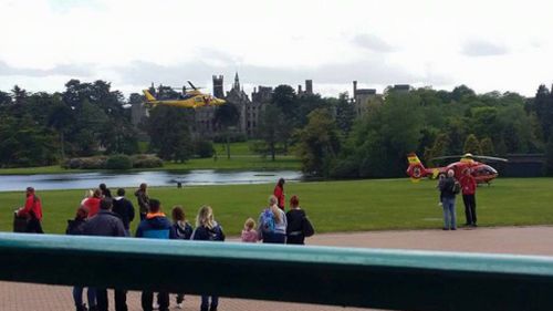 Bystanders watch as two emergency services helicopters land to treat injured passengers. (Facebook)