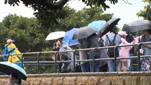 Brollies replaced bikinis in the city today. (9NEWS)