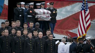 A joint military honor guard carries the casket of former President George H.W. Bush after it arrived by a presidential funeral train at Texas A&M University in College Station, Texas, for burial at the George Bush Presidential Library