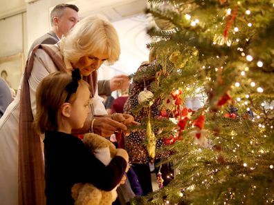 Camilla, Duchess of Cornwall decorates the Clarence House Christmas tree with children from various London charities in 2017.