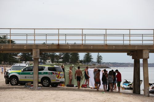 Police, ambulance and Surf Life Saving crew attend the scene of a suspected drowning next to Glenelg jetty. (AAP)