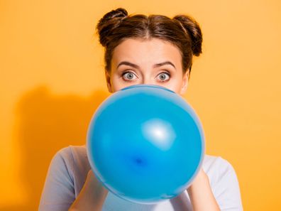 Woman blowing up balloon