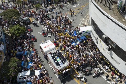 The casket of late Brazilian soccer great Pele is draped in the Brazilian and Santos FC soccer club flags as his remains are transported from Vila Belmiro stadium, where he laid in state, to the cemetery during his funeral procession in Santos, Brazil, Tuesday, Jan. 3, 2023.