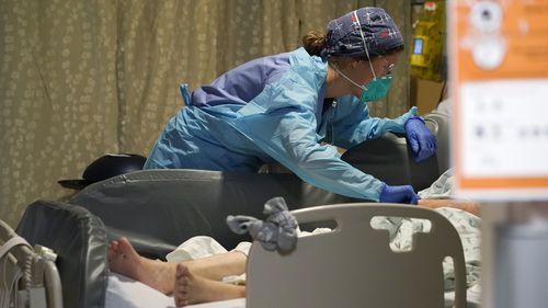 Registered nurse Estella Wilmarth tends to a patient in the acute care unit of Harborview Medical Center,  in Seattle. 