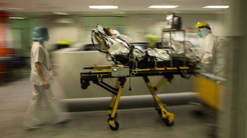 Medical staff transfer a COVID-19 patient, due to the lack of room, from the CHR Citadelle hospital in Liege, Belgium.