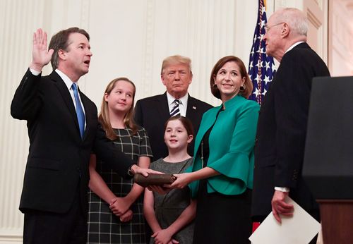 Trump listens as retired Supreme Court Justice Anthony Kennedy ceremonially swears-in Supreme Court Justice Brett Kavanaugh.