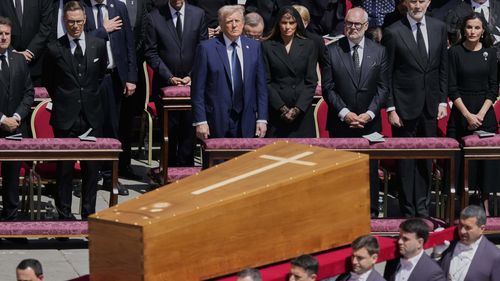 La bara di Papa Francesco viene portata davanti ai dignitari, tra cui il presidente Donald Trump durante i suoi funerali in Piazza San Pietro in Vaticano, il 26 aprile 2025.