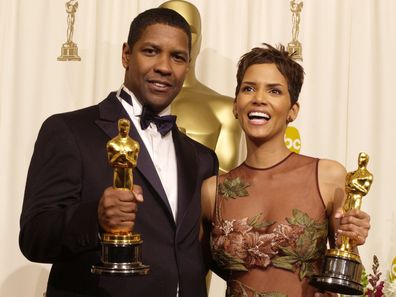 Actor and Actress in a Leading Role winners Denzel Washington and Halle Berry pose with their Oscars backstage in 2002.