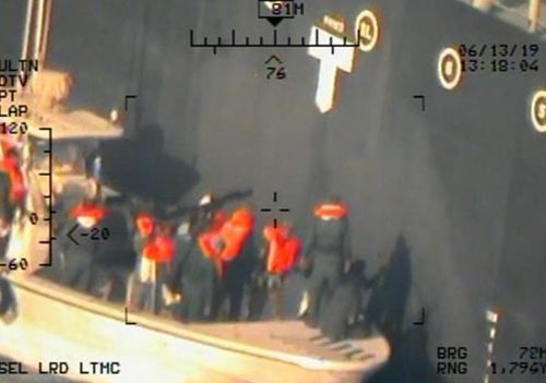 This image released by the US Department of Defence, taken from a US Navy helicopter, shows what the Navy says are members of the Islamic Revolutionary Guard Corps Navy removing an unexploded limpet mine from the M/T Kokuka Courageous.