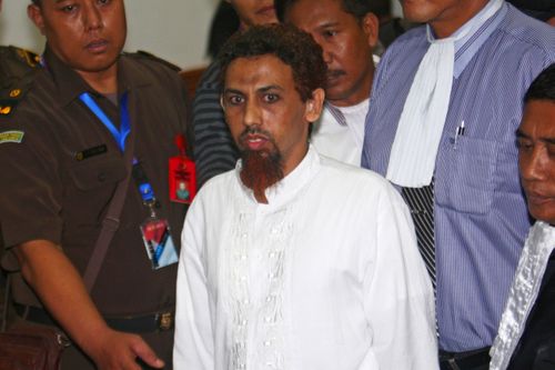 Le bombardier Umar Patek est escorté par des procureurs et des policiers en civil hors du tribunal