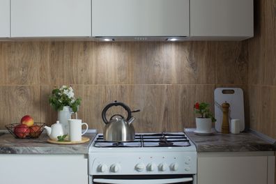 metal silver kettle on   gas stove  and teapotwith cup  in kitchen