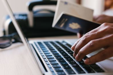 Passport and man in laptop computers, vacations or flight to tropical destination and Reading Hotel website, travel concept.