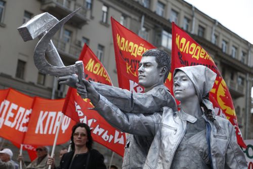 The people of Russia show pride in their history, pictured here in 2016 brandishing the famous hammer and sickle during a Communist Party march. (AAP)