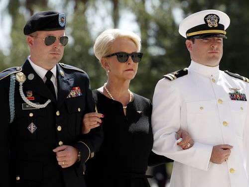 Cindy, escorted by sons, Jack McCain, right, and Jimmy McCain, following the casket.