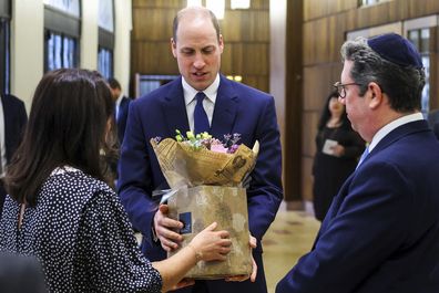 Prince William receives a bouquet of flowers for his wife Catherine, Princess of Wales, during his visit at the Western Marble Arch Synagogue, in London, Britain, Feb. 29, 2024.