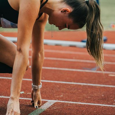 Stock image of a woman preparing to sprint.