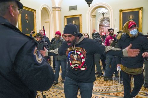FILE - In this January 6, 2021, photo, Trump supporters, including Douglas Jensen, center, confront U.S. Capitol Police in the hallway outside of the Senate chamber at the Capitol in Washington. The Iowa construction worker and QAnon follower was sentenced Friday, Dec. 16, 2022, to five years in prison for his role in the Jan. 6, 2021, insurrection.