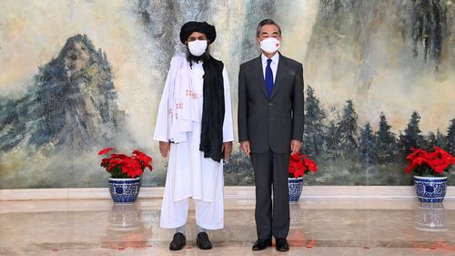 FILE - In this  July 28, 2021, file photo released by China's Xinhua News Agency, Taliban co-founder Mullah Abdul Ghani Baradar, left, and Chinese Foreign Minister Wang Yi pose for a photo during their meeting in Tianjin, China. China has expressed a willingness to hold talks with the U.S. to promote a soft landing in Afghanistan, while heavily criticizing Washington and again demanding that the Biden administration halt its attacks on China. (Li Ran/Xinhua via AP, File)