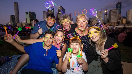 People pose for photos before the Brisbane fireworks.