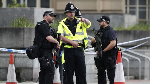 Armed police officers patrol a police cordon near the Manchester Arena in Manchester, Wednesday, May 24, 2017.