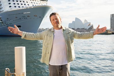 Jamie Oliver poses in front of the Royal Caribbean cruise ship Ovation of the Seas.