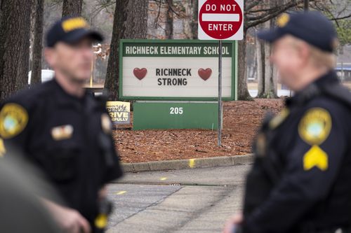FILE - Police look on as students return to Richneck Elementary on Jan. 30, 2023, in Newport News, Va. A grand jury in Virginia has indicted the mother of a 6-year-old boy who shot his teacher on charges of child neglect and failing to secure her handgun in the family's home, a prosecutor said Monday, April 10. (Billy Schuerman/The Virginian-Pilot via AP, File)