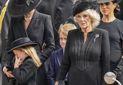 Kate, Princess of Wales, from left, Princess Charlotte, wiping her eye, Prince George, Camilla, the Queen Consort and Meghan, Duchess of Sussex follow the coffin of Queen Elizabeth II following her funeral service in Westminster Abbey in central London Monday Sept. 19, 2022. The Queen, who died aged 96 on Sept. 8, will be buried at Windsor alongside her late husband, Prince Philip, who died last year. (AP Photo/Martin Meissner, Pool)