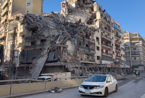 Um carro passa em frente a um prédio destruído que foi atingido por um ataque aéreo israelense em Dahiyeh, subúrbio ao sul de Beirute, Líbano, quinta-feira, 5 de março de 2026. (AP Photo/Hussein Malla)