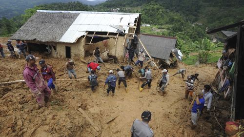 Rescuers search for victims at a village hit by a landslide in Sirnaresmi, West Java, Indonesia, Tuesday, Jan. 1, 2019.
