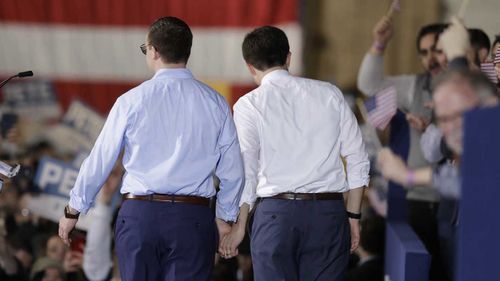 Pete Buttigieg holds hands with his husband Chasten, a teacher.