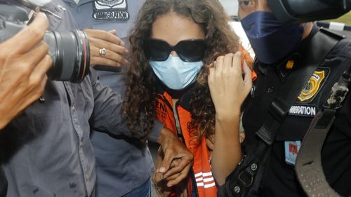 Heather Mack of Chicago, Ill., centre, escorted by immigration officers to Immigration detention centre in Jimbaran, Bali, Indonesia on Friday, Oct. 29, 2021. 