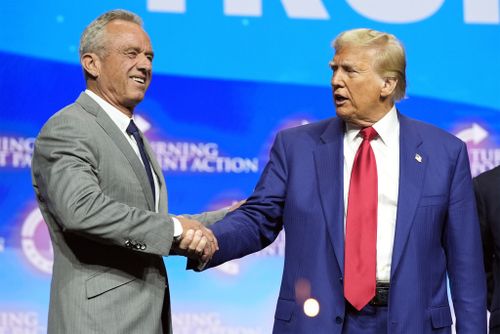 Republican presidential nominee former President Donald Trump shakes hands with Robert F. Kennedy Jr.