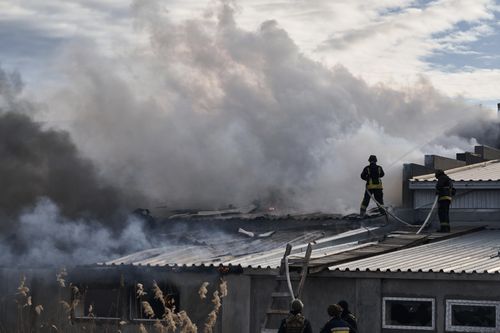 Ukrainian State Emergency Service firefighters put out the fire after the Russian shelling hit an industrial area in Kherson, Ukraine, Friday, February 3, 2023.